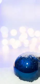 Snowy winter ornaments with bokeh lights on mobile wallpaper.