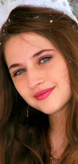 Portrait of a young woman with brown hair and blue eyes, surrounded by snow.