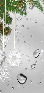 Rainy window with hanging snowflakes and evergreen leaves phone wallpaper.