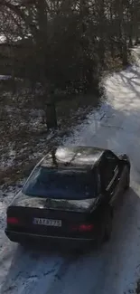 Car driving on a snowy forest road during winter.