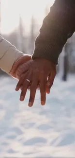 Couple holding hands in snowy forest, winter romance scene.