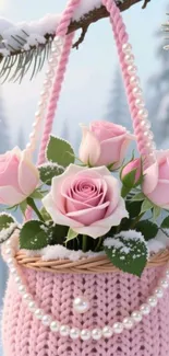Pink roses in a knitted basket adorned with pearls in a snowy landscape.
