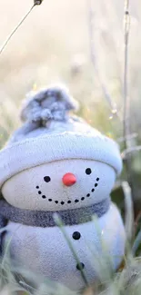 Adorable snowman in frosty grass with a scenic winter backdrop.