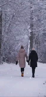 Two friends walking in a snow-covered forest path during winter.