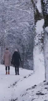 Snowy forest path with two people walking in winter.