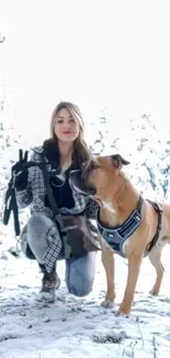 Woman with dog in snowy winter landscape.