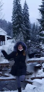 Woman enjoying winter scene with snowy trees and flowing river.