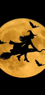 Silhouette of witch flying across a full moon on a Halloween night.