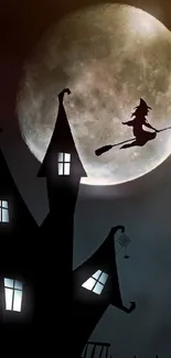 Silhouetted witch flying over a haunted house with full moon backdrop.