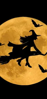 Silhouette of witch flying on broomstick with bats against full orange moon.