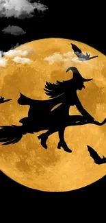 Witch silhouette flying on broomstick across glowing amber full moon with bats in night sky.