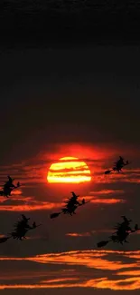 Silhouetted witches flying against an orange sunset sky, creating an enchanting scene.