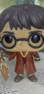 Wizard pop figure holding a broom on an open book.