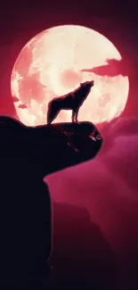 Silhouetted wolf howling at red full moon in dramatic night sky.