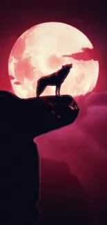 Wolf silhouette against a vivid pink moon and dark night sky.