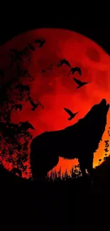 Silhouette of howling wolf against glowing red moon with birds flying by.