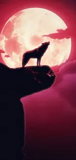 Wolf silhouette on cliff with red moon backdrop.