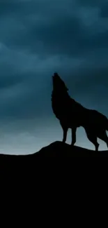 Silhouette of a howling wolf against a dark blue sky.