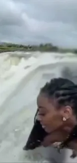 Woman exploring at the waterfall edge.