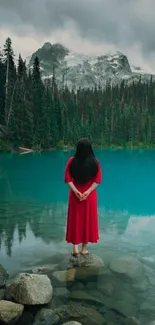 Woman in red dress by turquoise mountain lake.