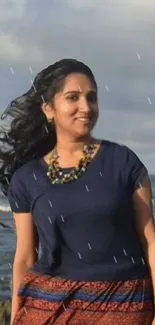 Smiling woman by the ocean, raindrops falling.