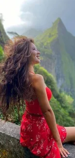 Woman in red dress sitting by mountains.