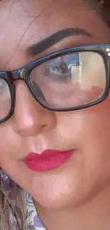 Close-up of a woman with glasses and red lipstick.