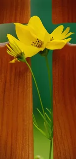 Yellow flower through wooden cross on green background.