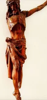 Wooden crucifix sculpture against a plain background.