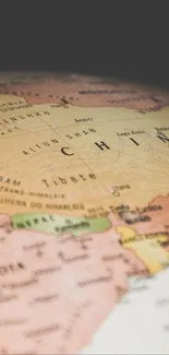 Mobile wallpaper featuring globe with Asia map focus.
