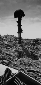 WWII battlefield memorial with helmet silhouette in somber scenery.