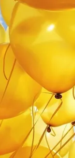 Vibrant yellow balloons float against a clear blue sky.