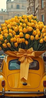 Yellow car topped with a large tulip bouquet on a city street.