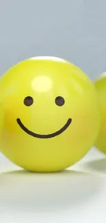 Three yellow spheres with smiley and frowny faces as wallpaper.