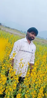 Man standing in vibrant yellow flower field, under cloudy sky.