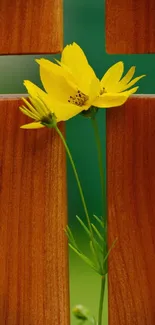 Yellow flower against a wooden cross, creating a serene and peaceful wallpaper.