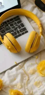 Yellow headphones on a laptop with roses on a bed, creating a cozy scene.