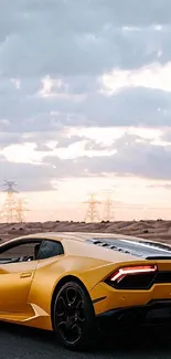 Yellow sports car on a desert road with sunset clouds.