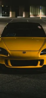 Yellow sports car parked at night.