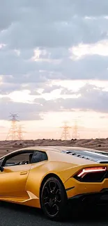 Yellow sports car drives on a desert road under a cloudy sunset sky.
