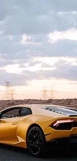 Yellow sports car on desert road with cloudy sky background.