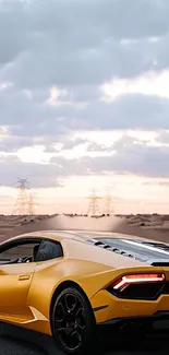 Yellow sports car on desert road with cloudy sky backdrop.