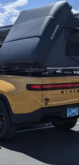 Yellow Rivian truck with rooftop tent.