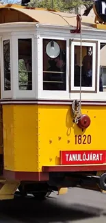 Yellow vintage tram with urban background.