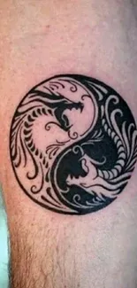 Yin yang tattoo design in black and white on skin.