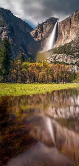 Majestic Yosemite waterfall with reflection in a serene pond.