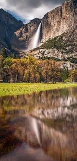 Yosemite waterfall reflecting on a tranquil lake with vibrant fall colors in the foreground.