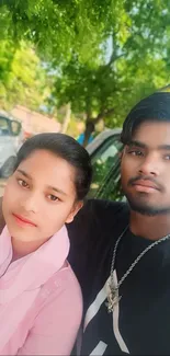 Young couple enjoying a sunny day outdoors with lush greenery.