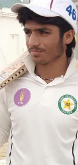 Young cricketer in white uniform holding a bat, standing outdoors.