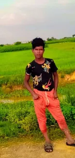 Young man in a lush green field wearing casual clothes.